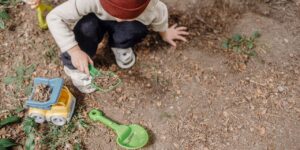 a boy digs in the dirt outside