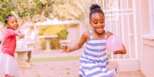 girls playing and running with a balloon