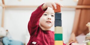 a girl stacks rainbow blocks