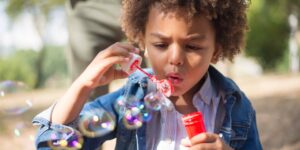 a boy blows bubbles