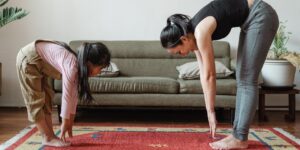 girl and mom stretch together