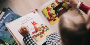 a kid reads a book with a parent