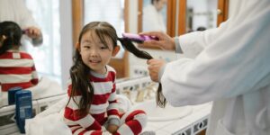 little girl having her hair brushed