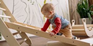 toddler climbing up wooden play ladder