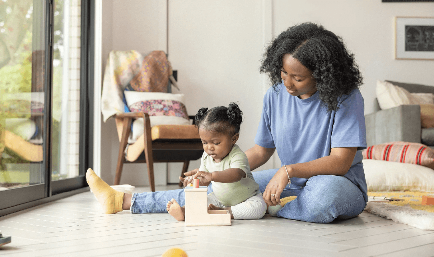 Mom and daughter play blocks together.